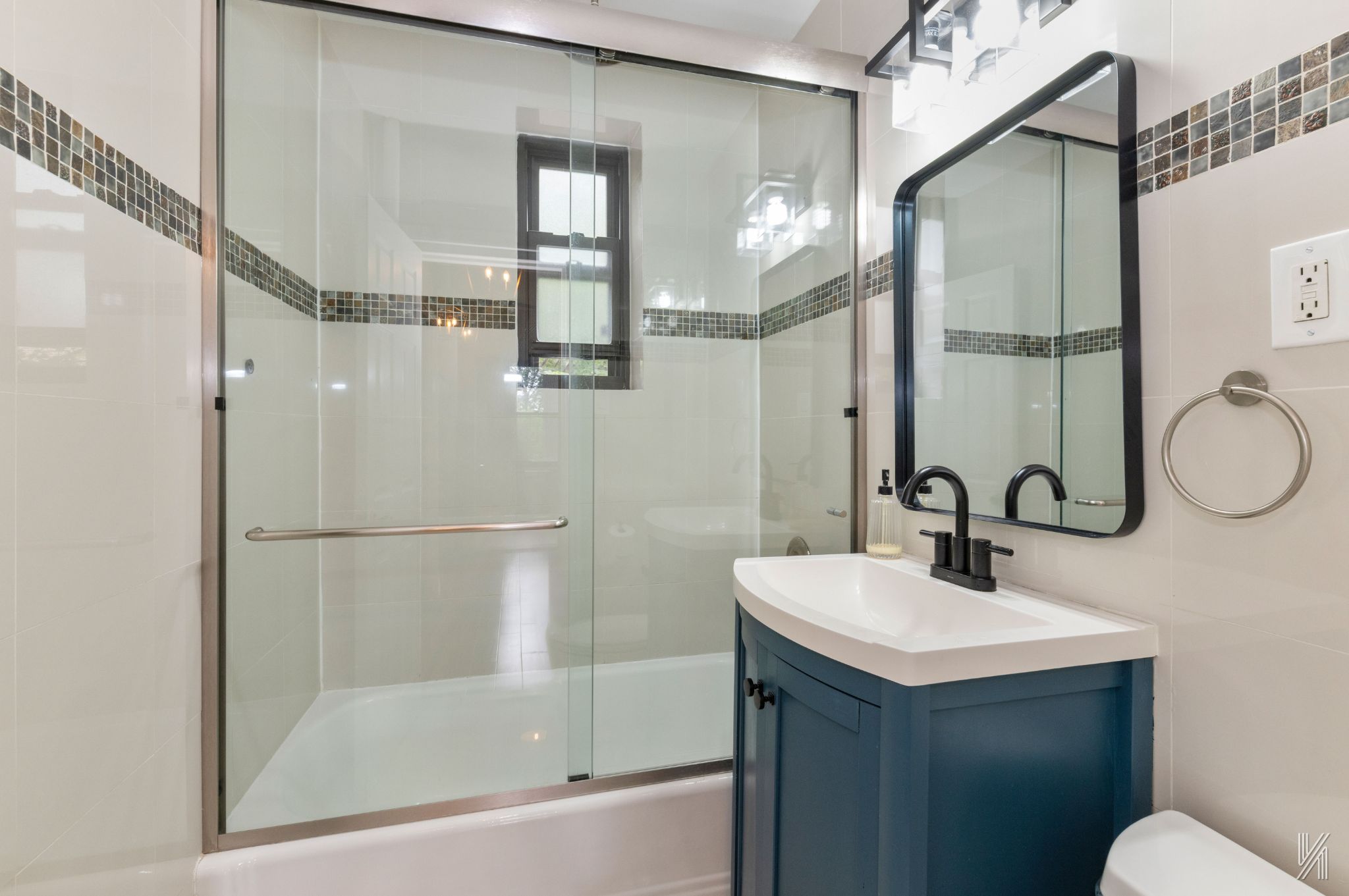 22-31 77th Street, Unit C2 Queens, NY 11370 - Photo 13 of 17 a bathroom with a sink mirror and a shower