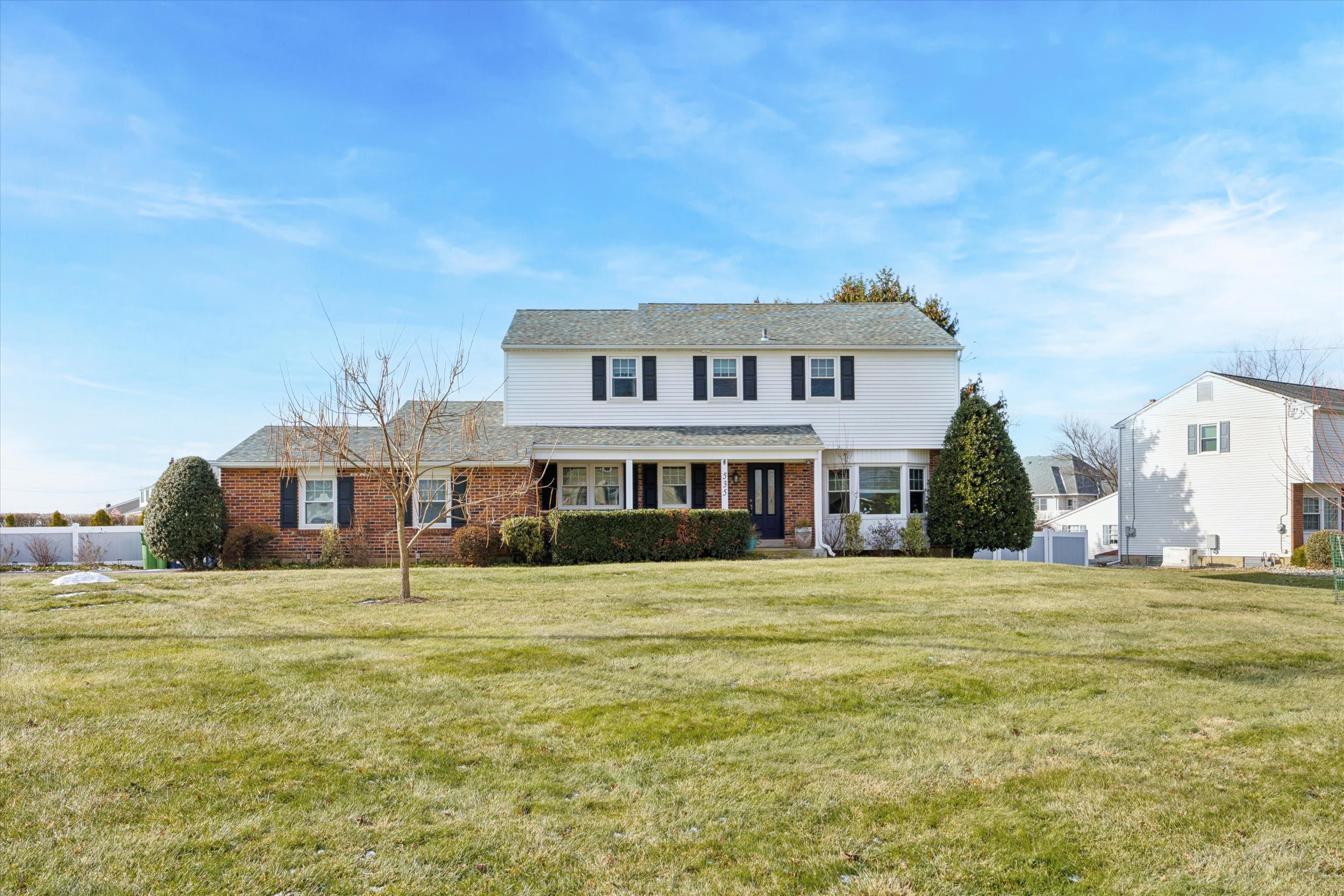 a big house with tall trees in front of it