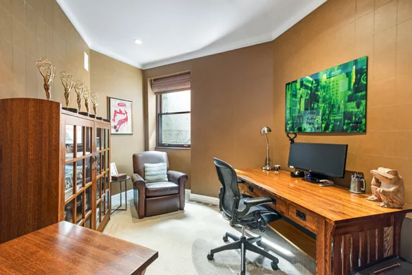 a view of a workspace with furniture and a window