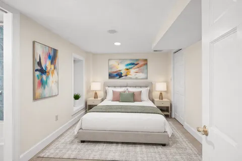 a bedroom with a bed and painting on the wall