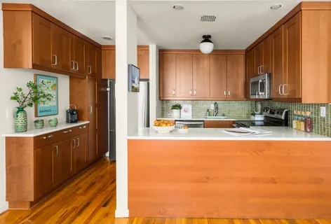 a kitchen with stainless steel appliances wooden cabinets a stove top oven a sink and dishwasher with wooden floor