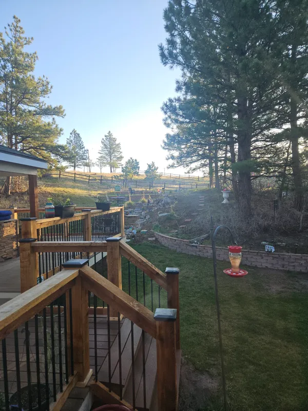 a backyard of a house with an outdoor seating and trees
