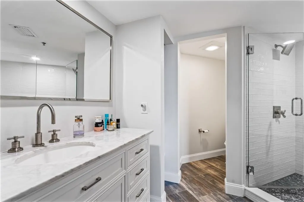 a bathroom with a granite countertop sink mirror vanity and toilet