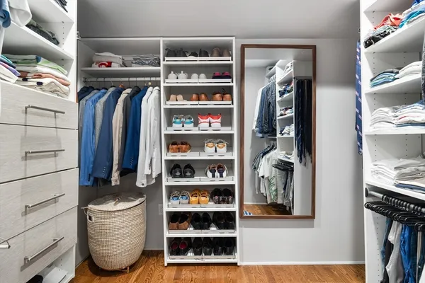 a view of walk in closet with clothes and shoes