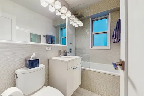 a bathroom with a toilet a sink a mirror and bathtub
