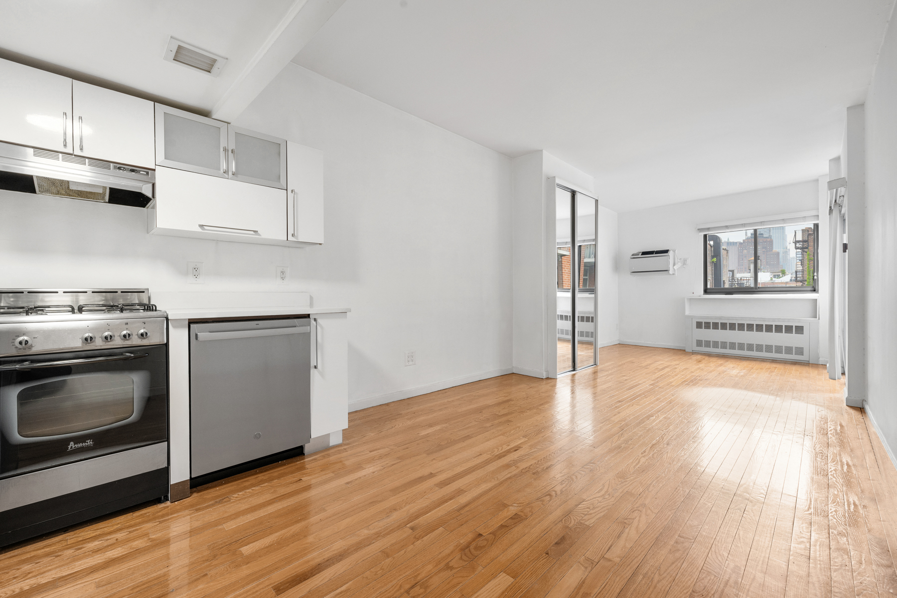 184 Thompson Street, Unit 4U Manhattan, NY 10012 - Photo 1 of 9 a kitchen with granite countertop a stove and a wooden floors
