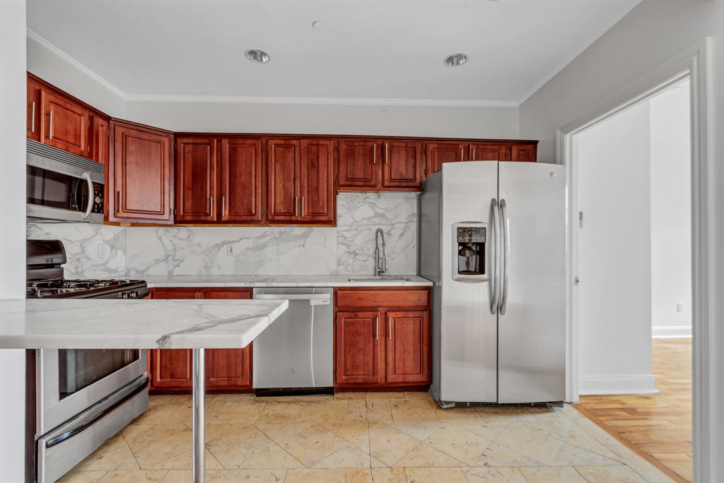 2098 Frederick Douglass Boulevard, Unit 5E Manhattan, NY 10026 - Photo 4 of 8 a kitchen with stainless steel appliances granite countertop a refrigerator and a stove top oven