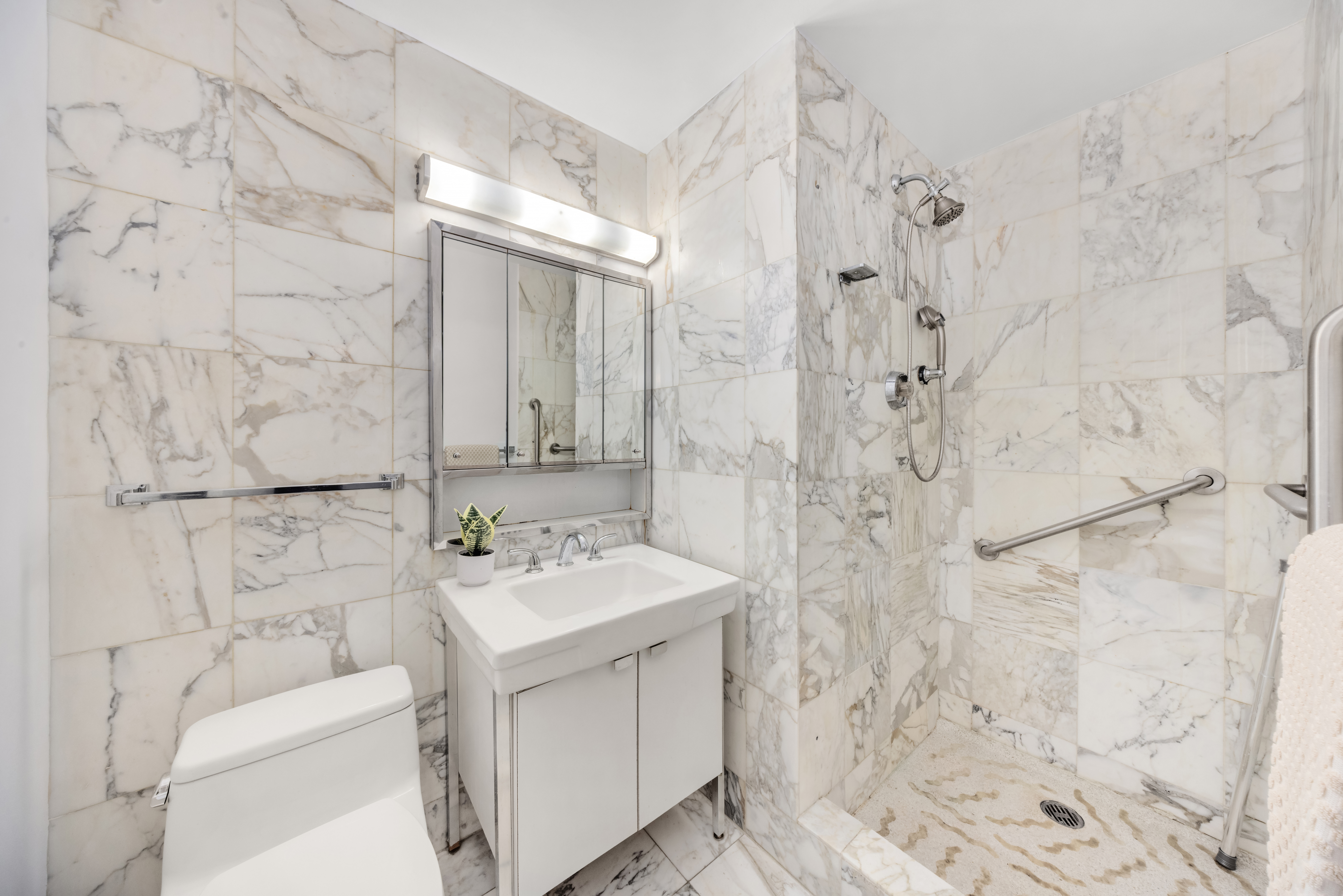 870 United Nations Plaza, Unit 14F Manhattan, NY 10017 - Photo 11 of 16 a bathroom with a sink toilet and shower