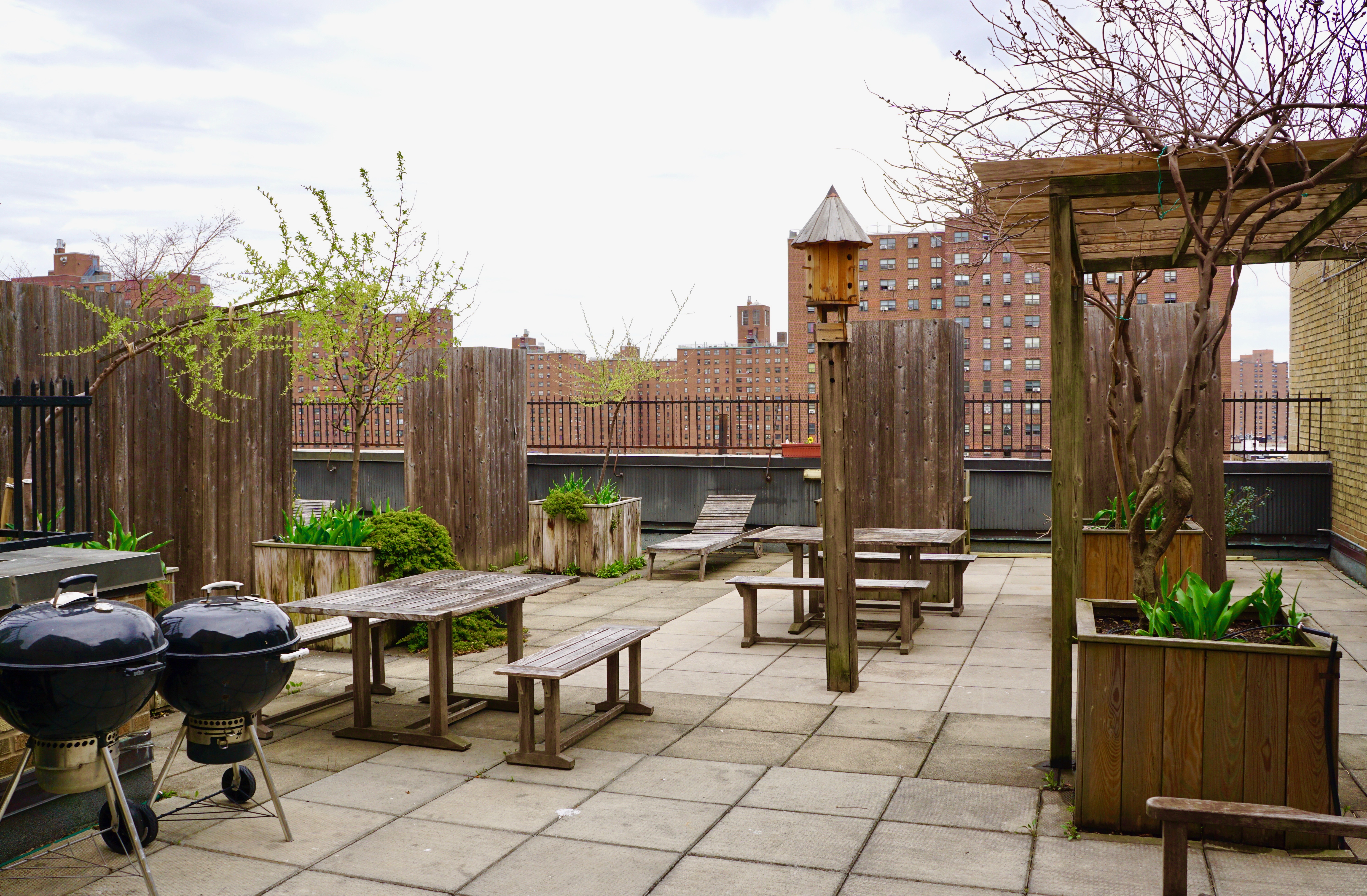 1255 5th Avenue, Unit 5J Manhattan, NY 10029 - Photo 12 of 17 a view of a patio with couches and a table and chairs with wooden floor