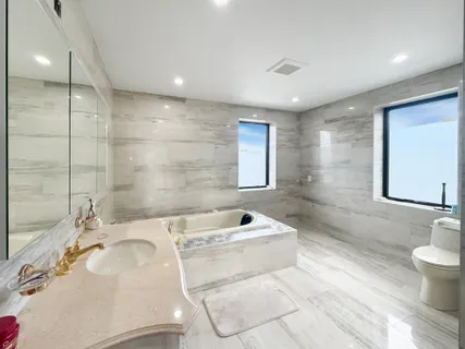a bathroom with a tub sink and mirror