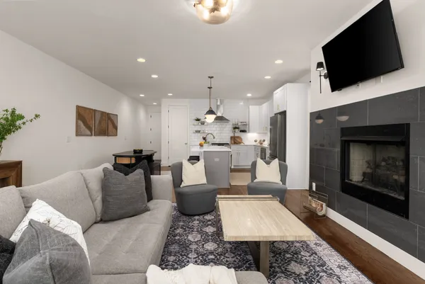 a living room with furniture a flat screen tv and a fireplace