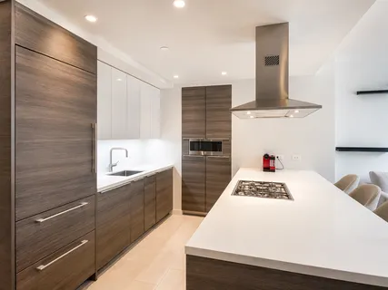 a kitchen with granite countertop a sink stainless steel appliances and white cabinets