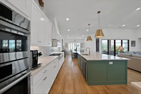 a large kitchen with stainless steel appliances lots of counter space and a wooden floors