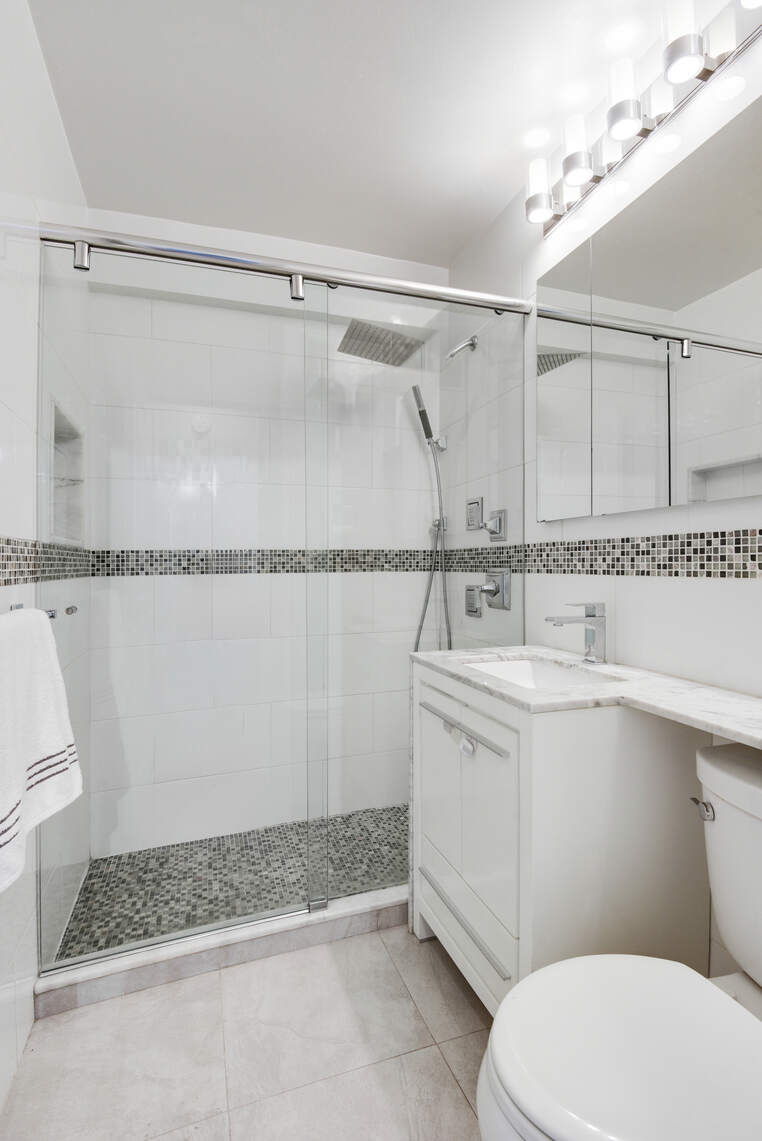 520 East 76th Street, Unit 11C Manhattan, NY 10021 - Photo 7 of 15 a bathroom with a sink a mirror and a toilet