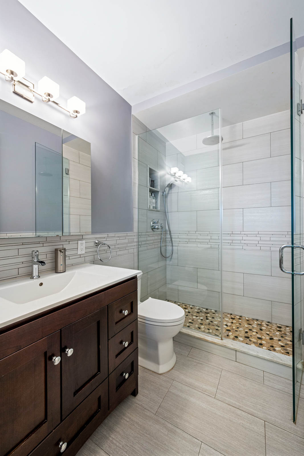 301 West 57th Street, Unit 44E Manhattan, NY 10019 - Photo 5 of 11 a bathroom with a double vanity sink toilet and shower