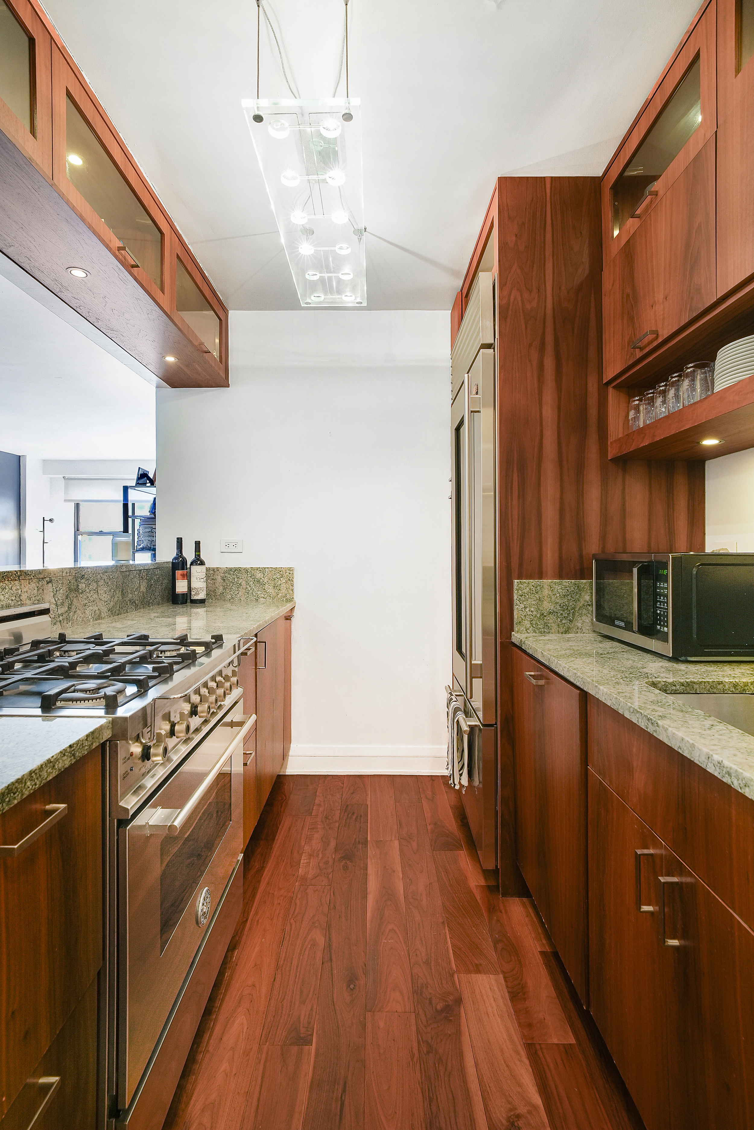 220 East 54th Street, Unit 11H Manhattan, NY 10022 - Photo 3 of 13 a kitchen with stainless steel appliances granite countertop a stove and a sink