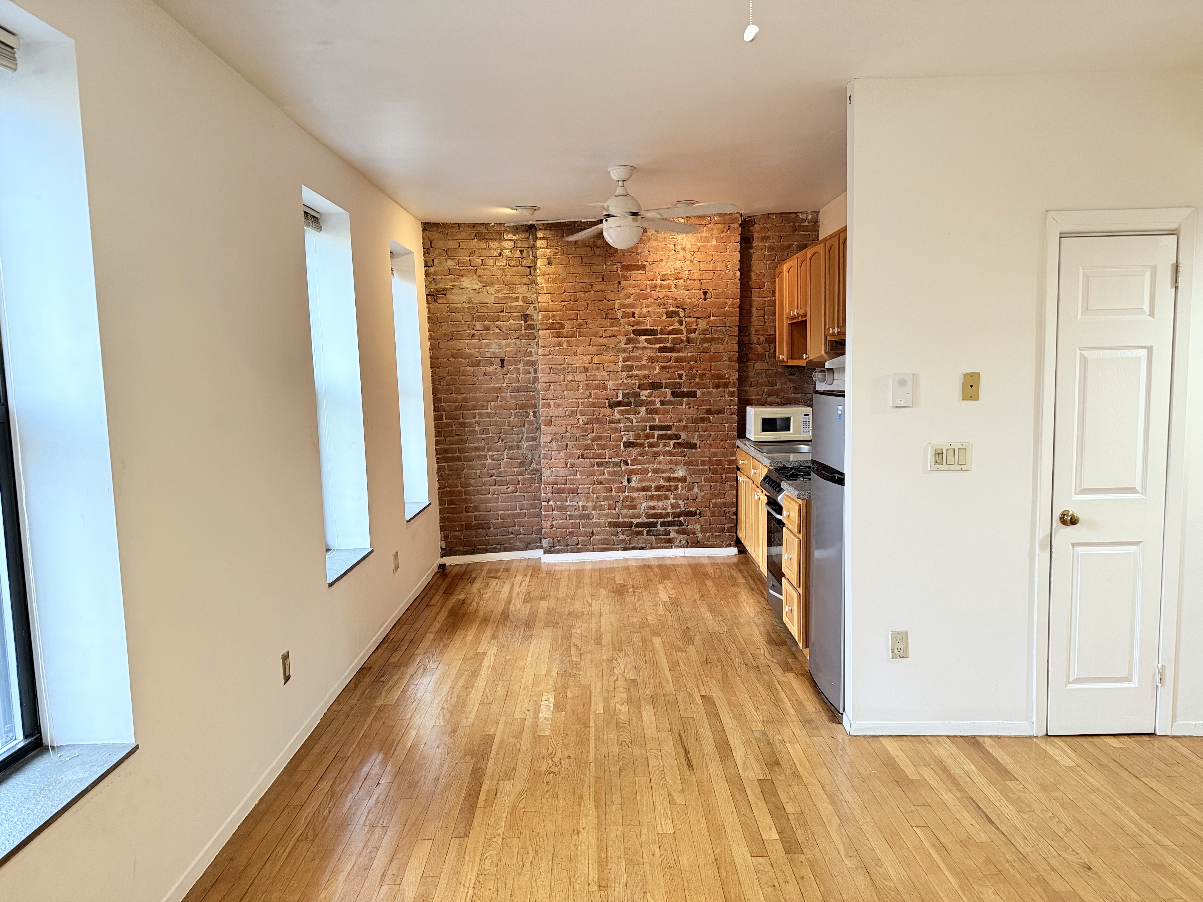 1672 Park Avenue, Unit 4A Manhattan, NY 10035 - Photo 5 of 11 a view of empty room with wooden floor and cabinet