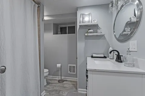 a bathroom with a toilet sink and mirror