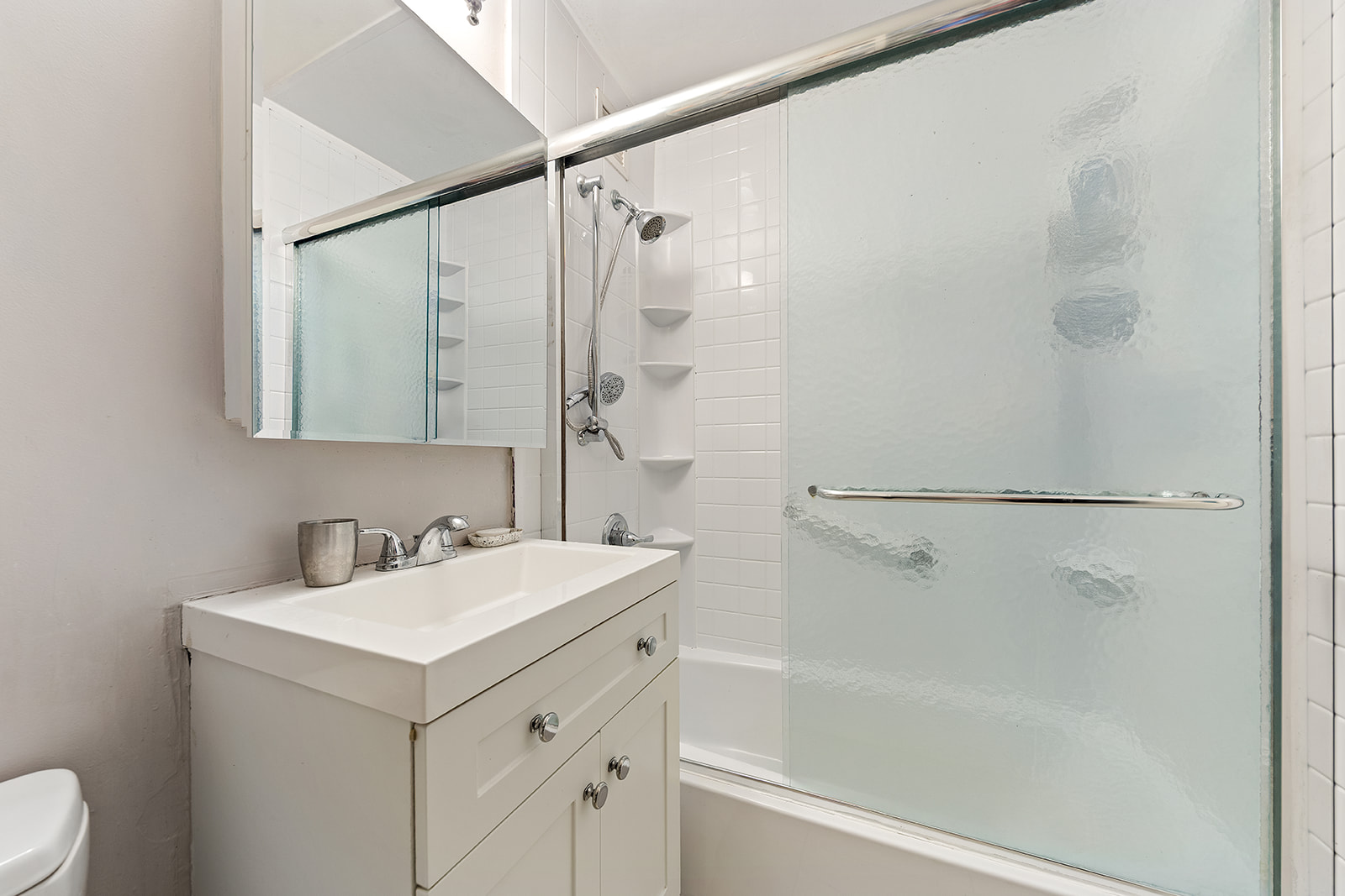 680 Washington Street, Unit 1B Manhattan, NY 10014 - Photo 5 of 13 a bathroom with a sink a mirror and a shower
