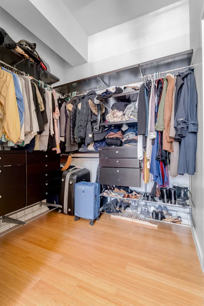 a view of walk in closet with clothes and shoes