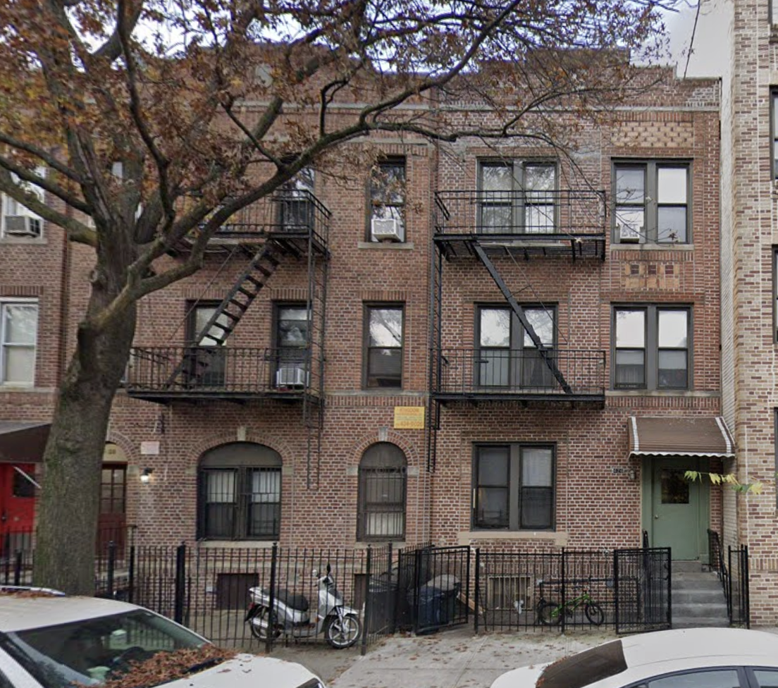 a front view of a building with glass windows and a street