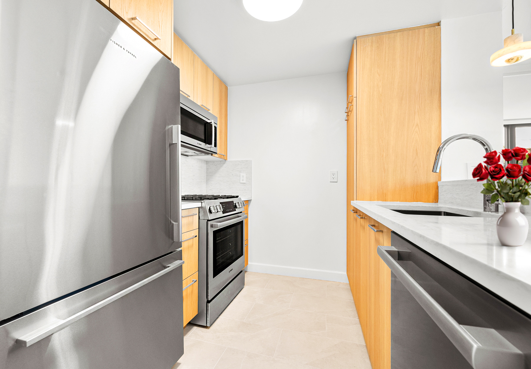 425 Main Street, Unit 9F Manhattan, NY 10044 - Photo 5 of 15 a kitchen with stainless steel appliances a sink stove and refrigerator