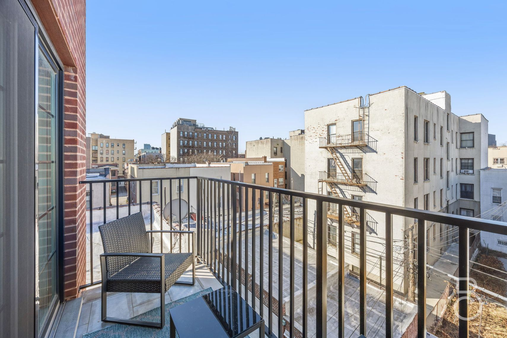 25-74 34th Street, Unit 4C Queens, NY 11103 - Photo 8 of 15 a view of a balcony with two chairs and a wooden fence
