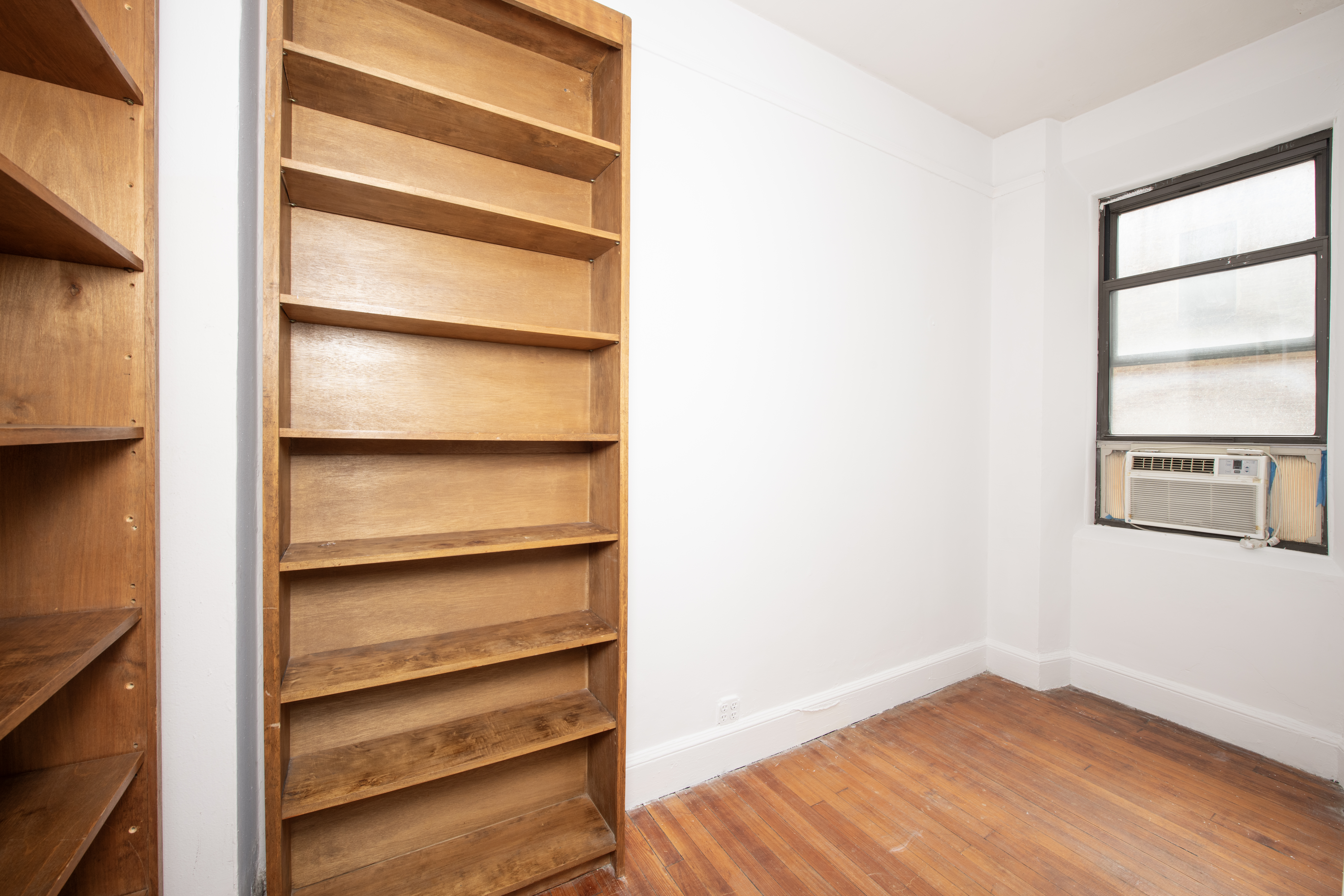 299 Riverside Drive, Unit 4D Manhattan, NY 10025 - Photo 12 of 15 a view of an empty room with a window and wooden floor
