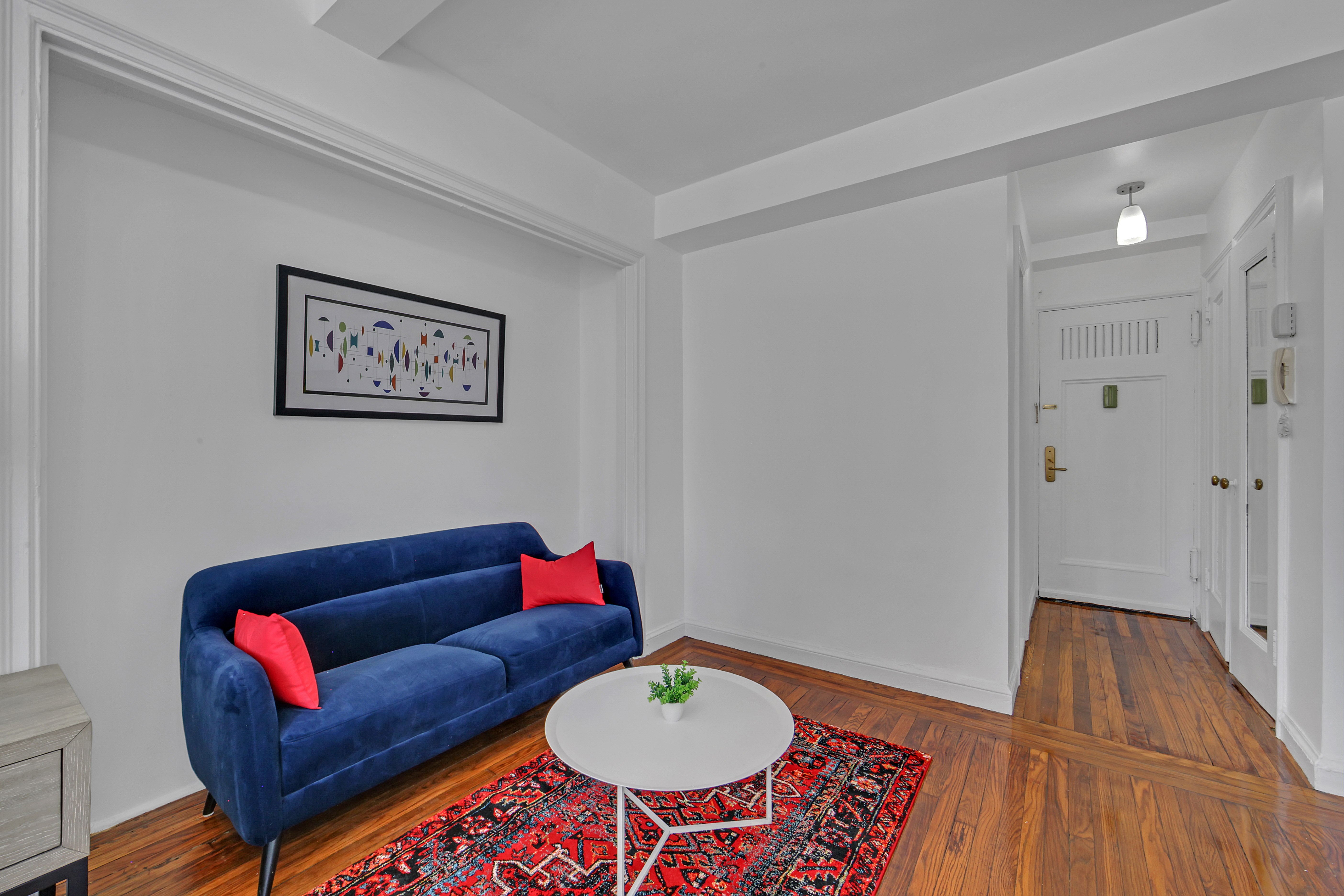 25 Tudor City Place, Unit 1202 Manhattan, NY 10017 - Photo 8 of 19 a living room with furniture and a wooden floor