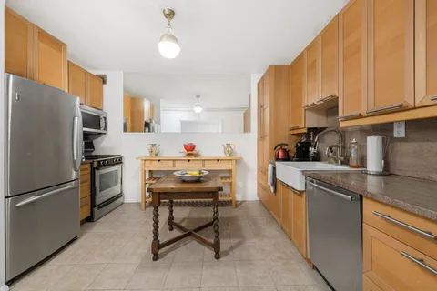 a kitchen with granite countertop a sink appliances and cabinets