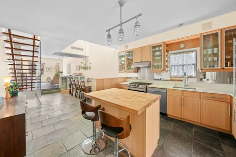 a kitchen with kitchen island a stove a sink and a refrigerator