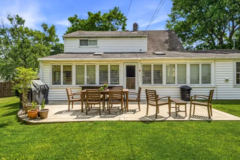a view of a house with backyard sitting area and garden