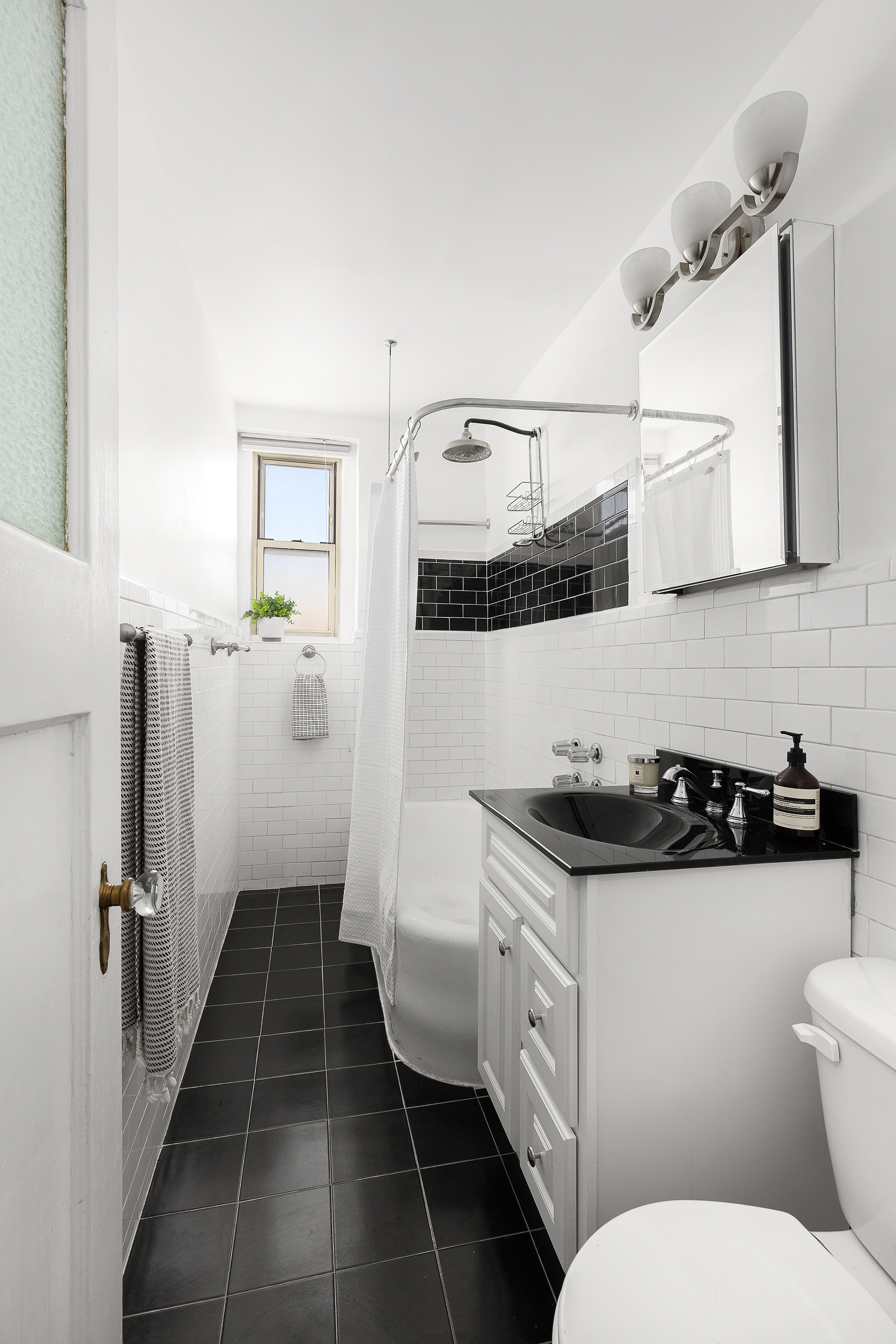 451 Clinton Avenue, Unit 3D Brooklyn, NY 11238 - Photo 6 of 8 a bathroom with a sink a toilet and a mirror