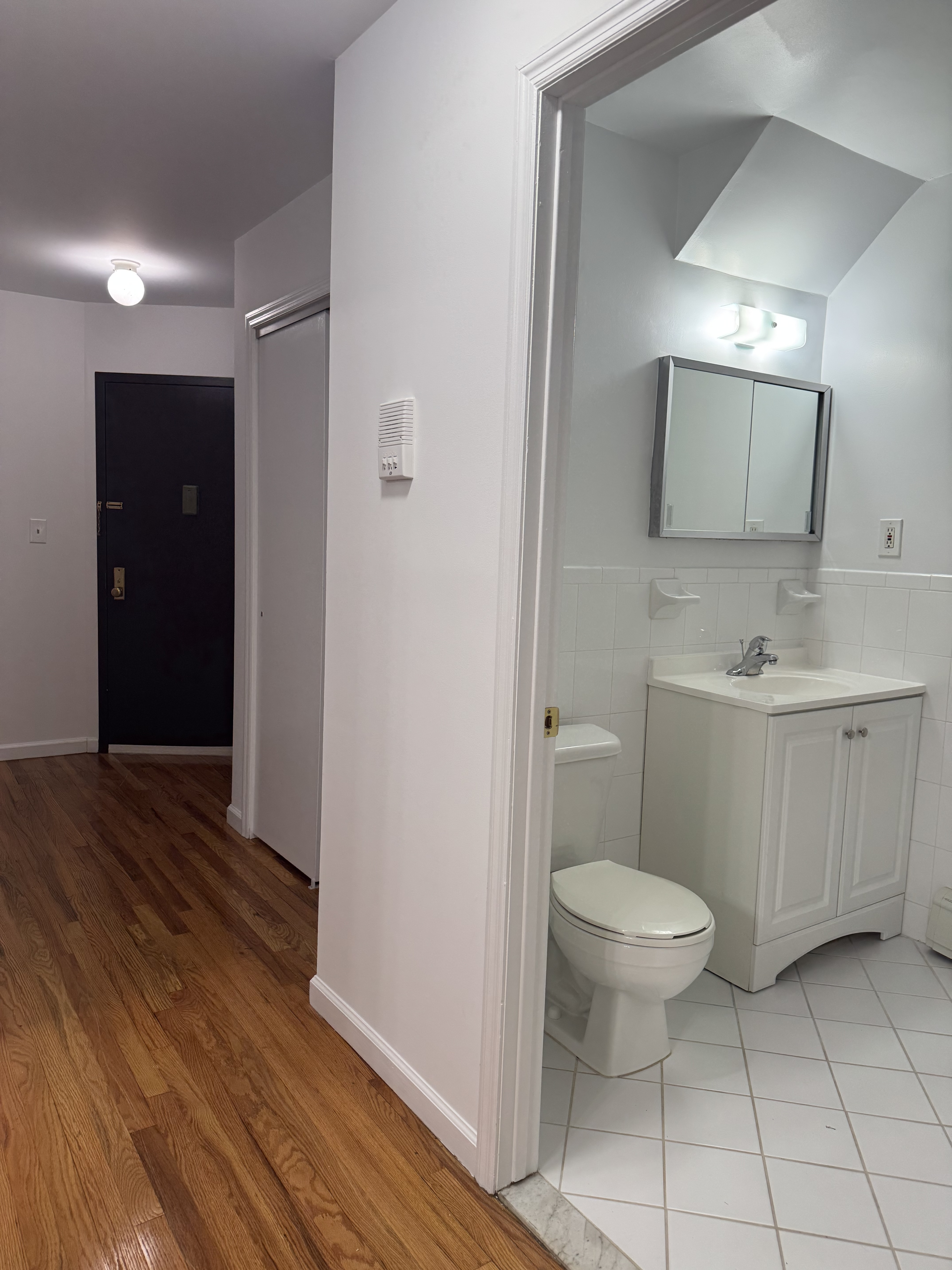 39-46 59th Street, Unit 1 Queens, NY 11377 - Photo 4 of 6 a bathroom with a sink a toilet a mirror and vanity