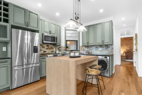 a kitchen with granite countertop a stove a refrigerator and a fireplace