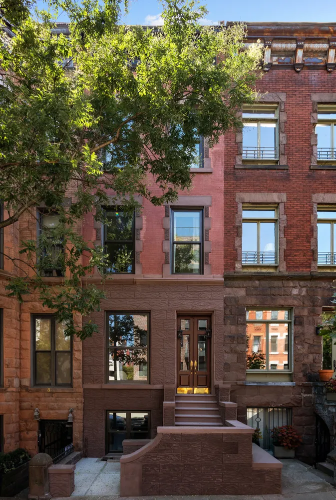 a front view of a building with glass windows and a tree
