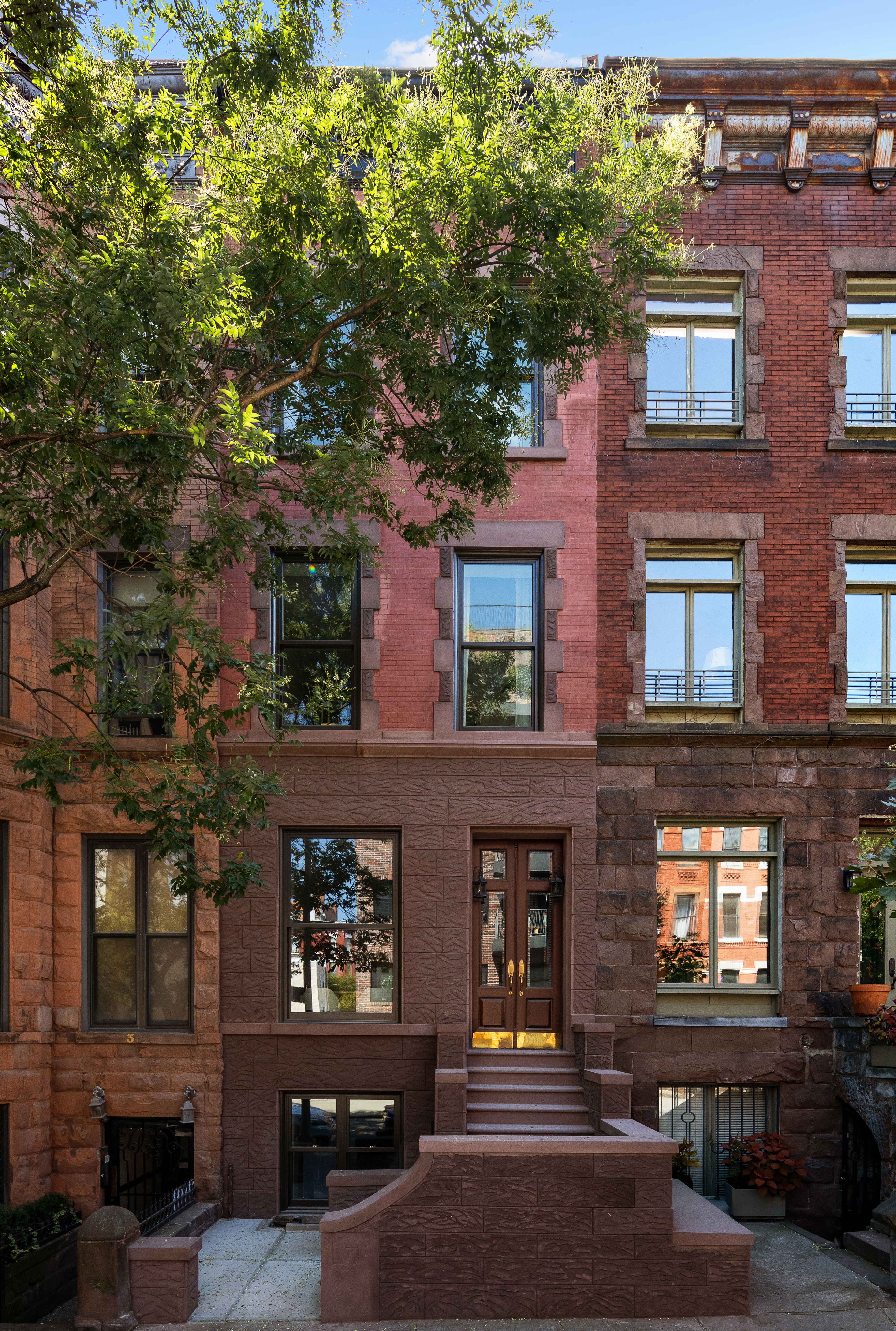 304 West 137th Street Manhattan, NY 10030 - Photo 24 of 26 a front view of a building with glass windows and a tree