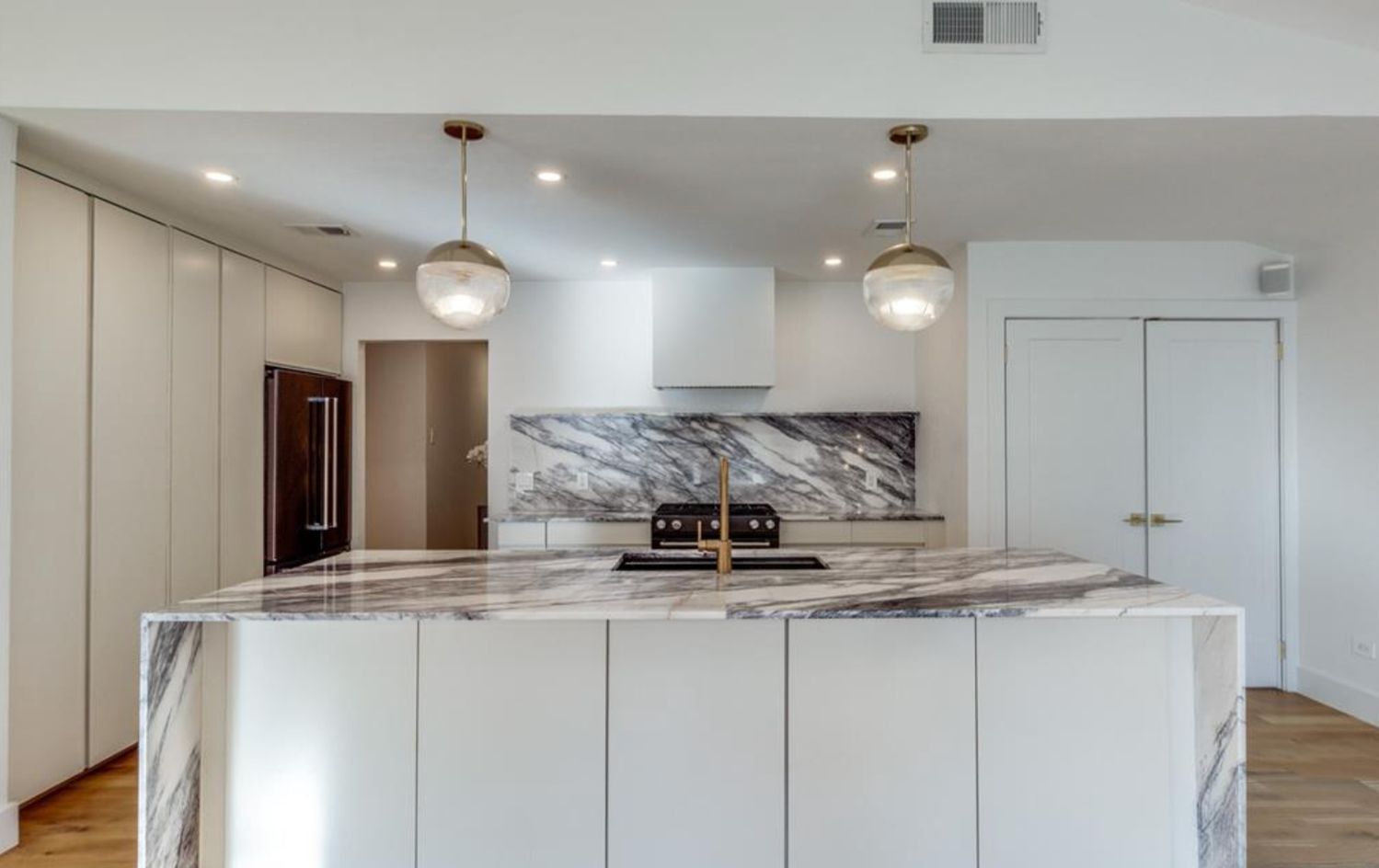 a view of a kitchen with stainless steel appliances granite countertop a sink and a refrigerator