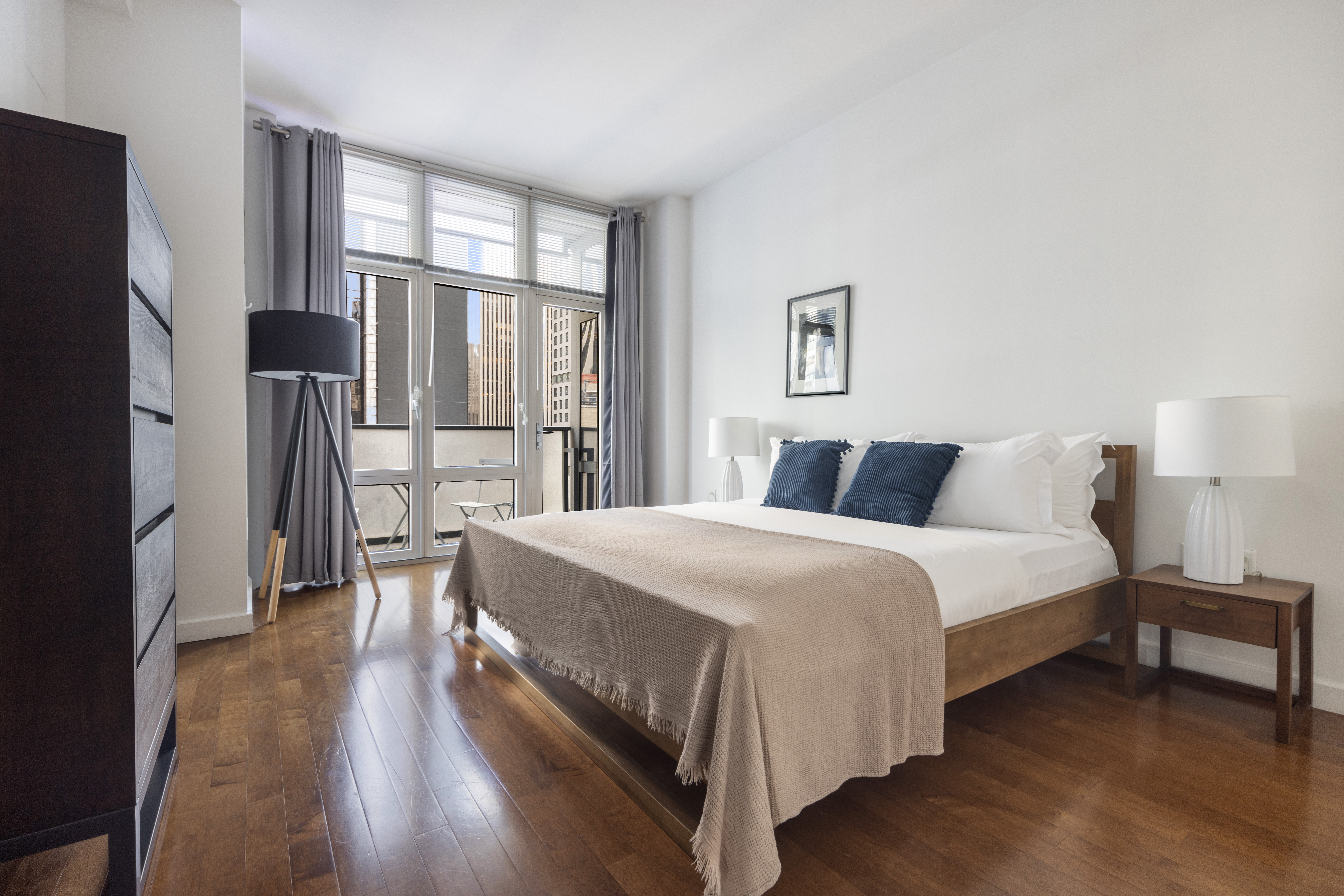 1600 Broadway, Unit 20A Manhattan, NY 10019 - Photo 2 of 6 a bedroom with a bed and a large mirror next to a window