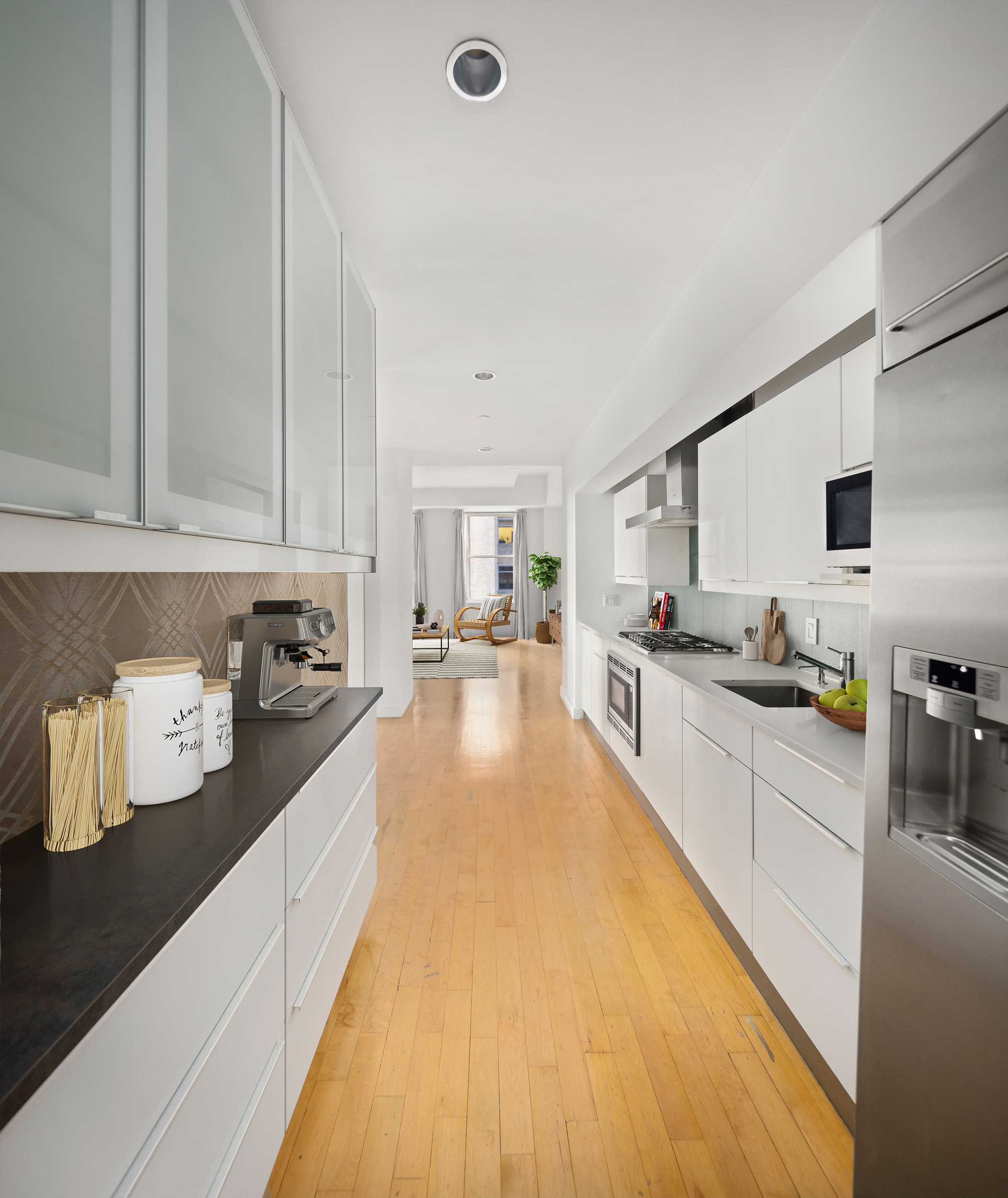 15 Broad Street, Unit 1100 Manhattan, NY 10005 - Photo 2 of 23 a large kitchen with kitchen island granite countertop a sink counter top space and stainless steel appliances