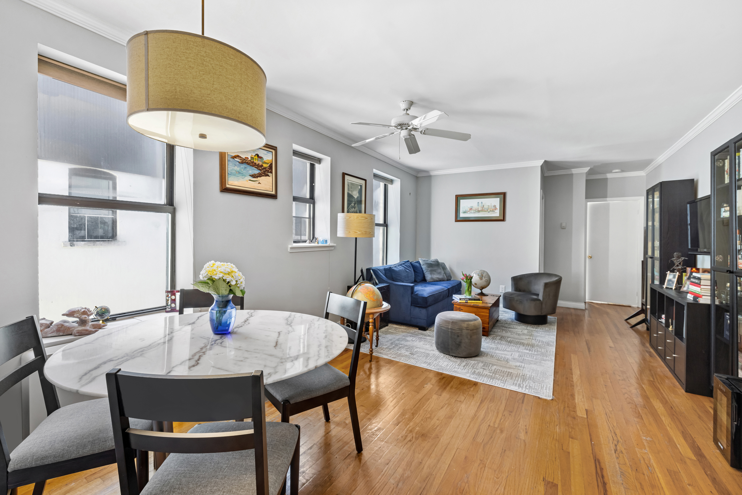 4 West 109th Street, Unit 6A Manhattan, NY 10025 - Photo 1 of 10 a living room with furniture a chandelier and a dining table