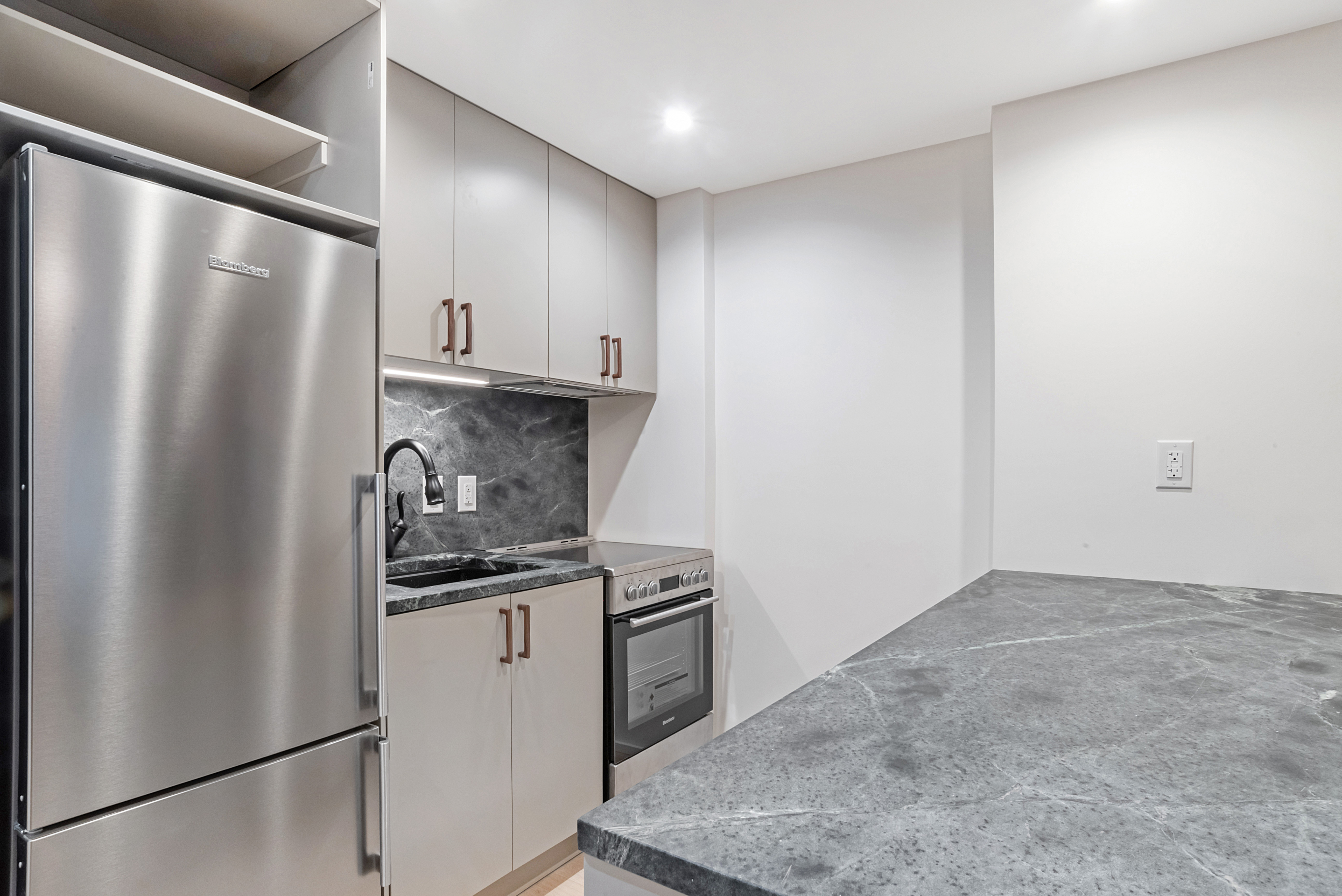 42 Monroe Street Brooklyn, NY 11238 - Photo 15 of 21 a kitchen with stainless steel appliances granite countertop a refrigerator a sink and white cabinets
