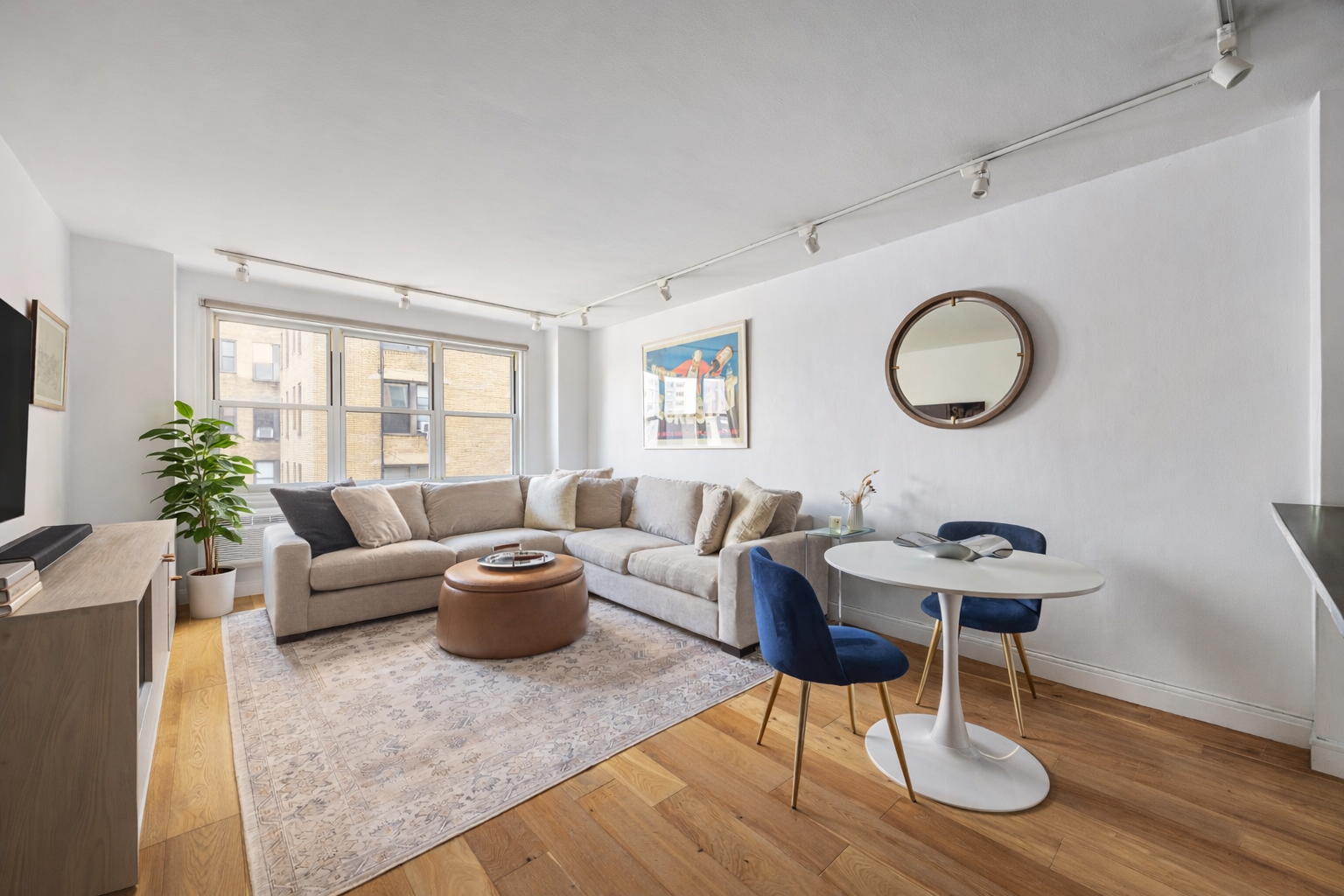 415 East 85th Street, Unit 7J Manhattan, NY 10028 - Photo 2 of 9 a living room with furniture a rug potted plant and a window