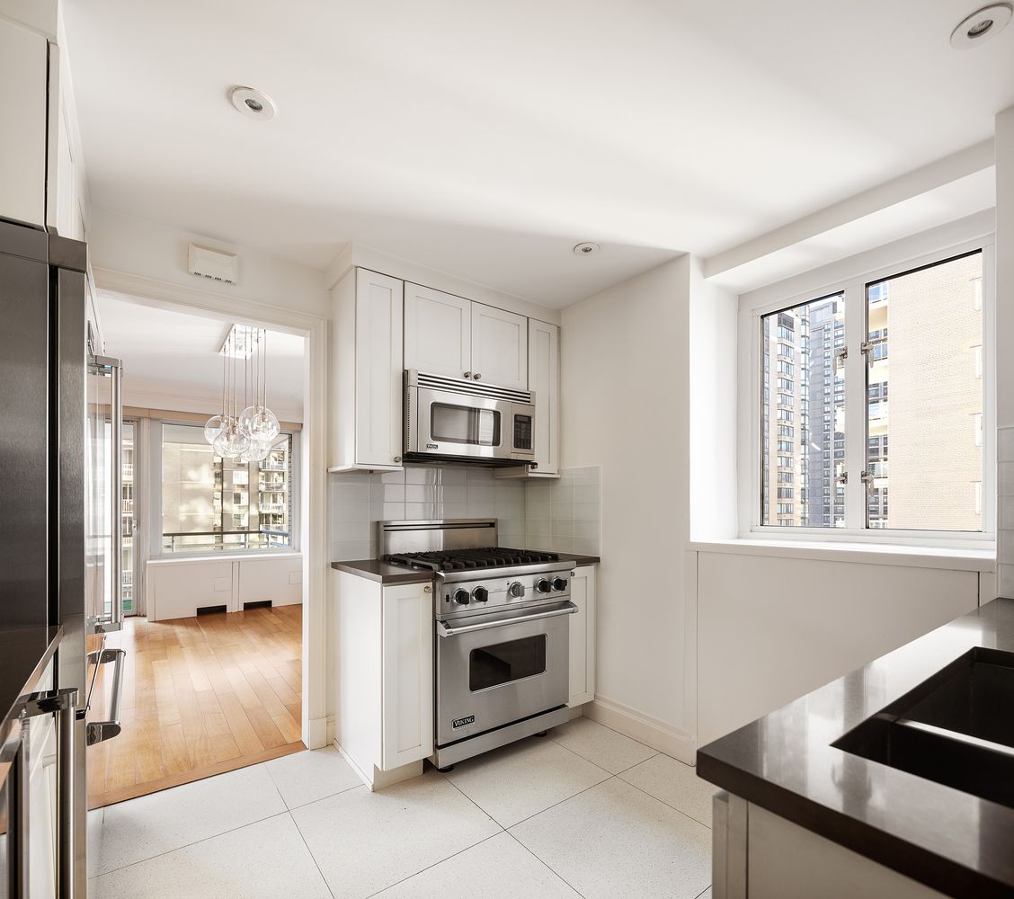 a kitchen with stainless steel appliances a stove a sink and a microwave