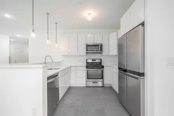 a kitchen with kitchen island a sink appliances and cabinets