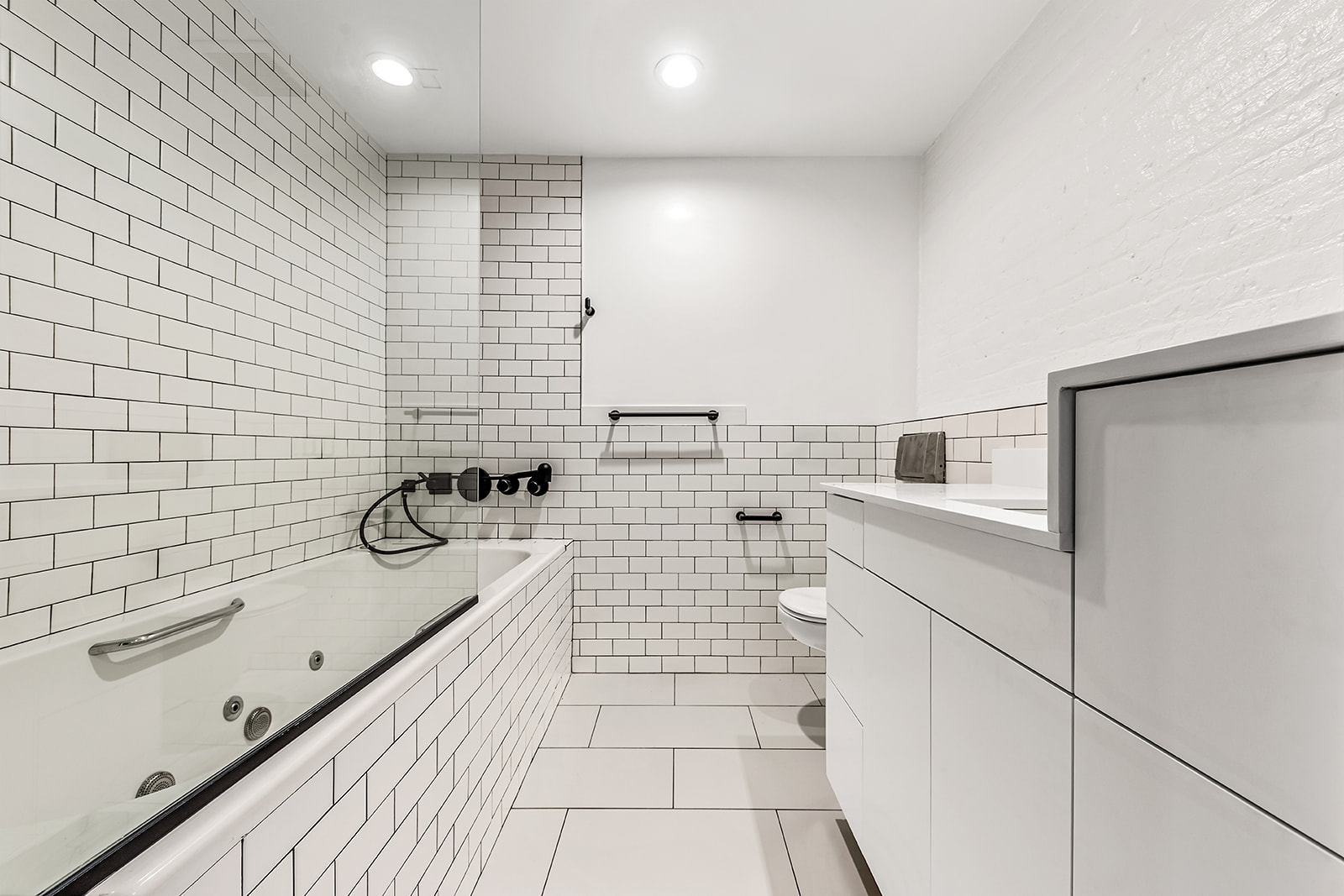 130 Watts Street, Unit 5N Manhattan, NY 10013 - Photo 9 of 11 a bathroom with a bathtub and shower