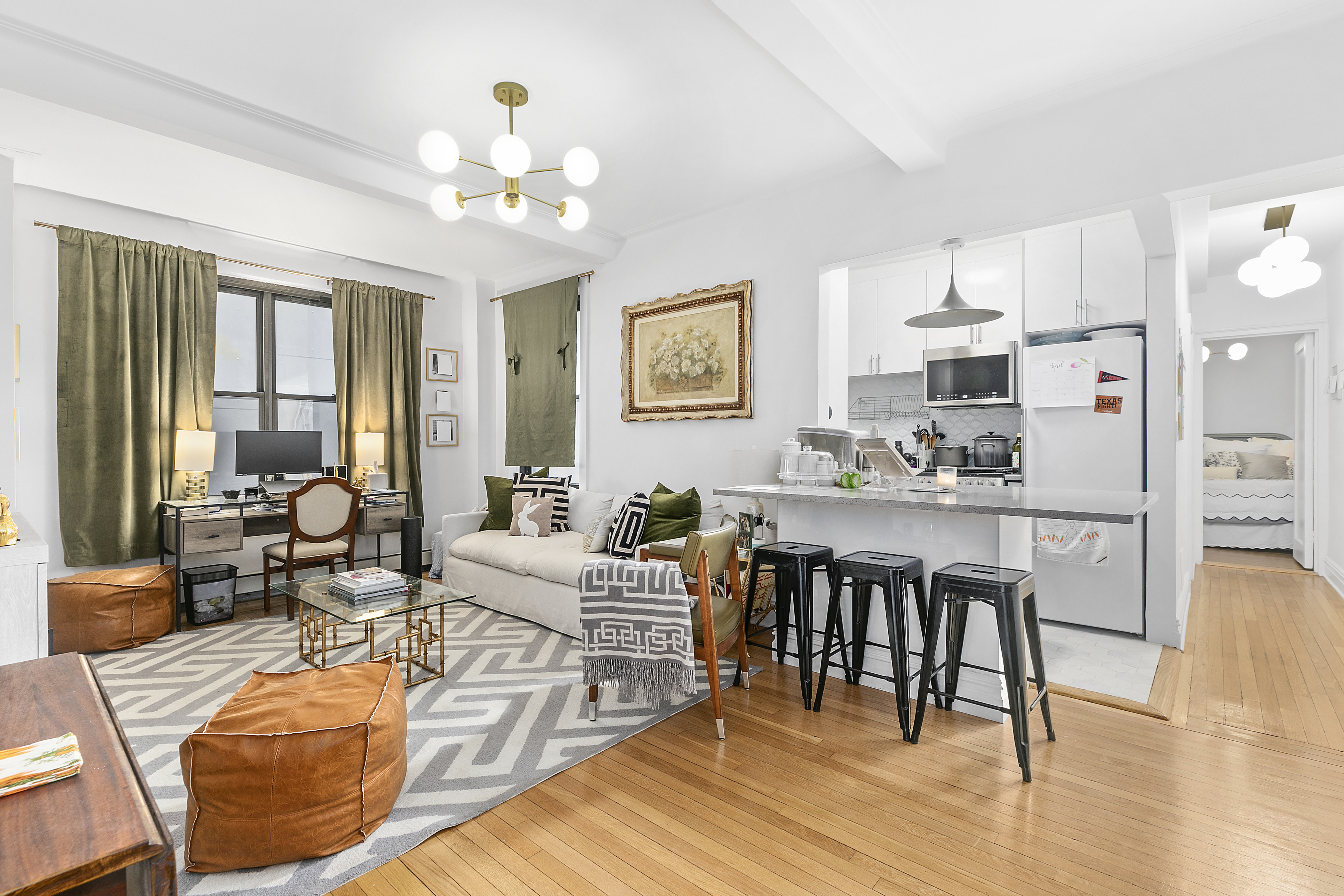 162 West 56th Street, Unit 602 Manhattan, NY 10019 - Photo 2 of 7 a living room with furniture a dining table and a chandelier