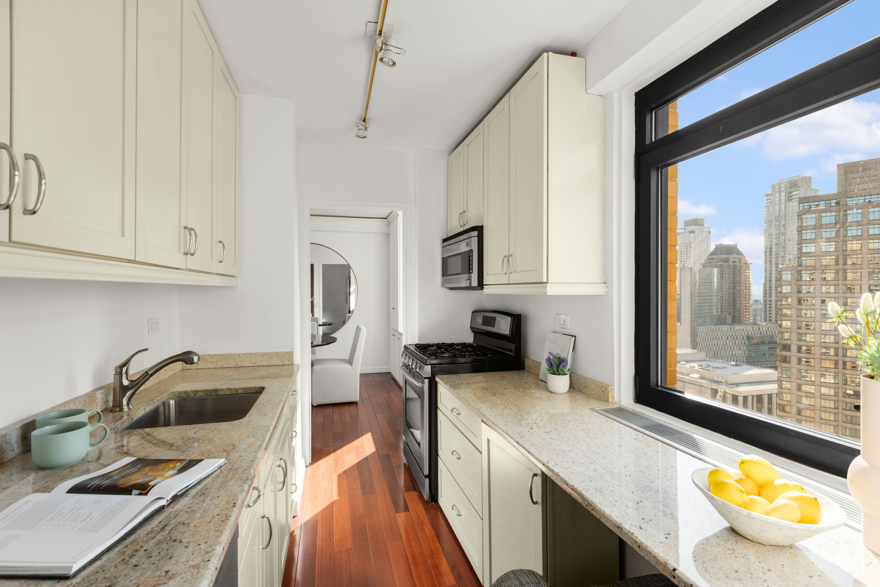 10 West 66th Street, Unit 29E Manhattan, NY 10023 - Photo 18 of 39 a kitchen with stainless steel appliances a sink a stove and a refrigerator