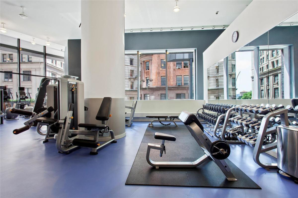 15 William Street, Unit 22H Manhattan, NY 10005 - Photo 17 of 20 a room with gym equipment and a large window