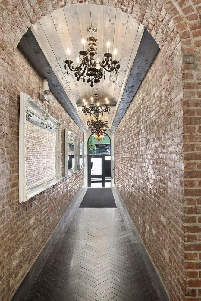 a view of a hallway with wooden floor and a chandelier